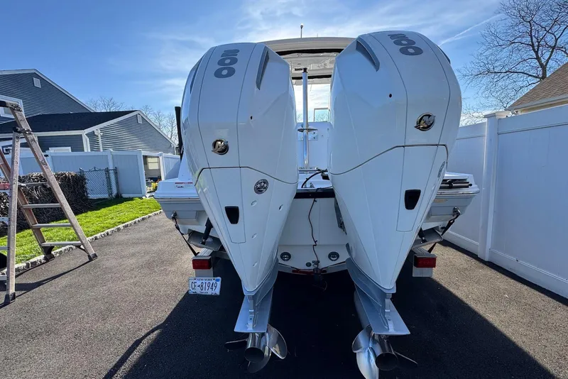 Slide: The Image of 2021 Blackfin 252 DC boat with dual outboard engines, parked in a driveway. - 36