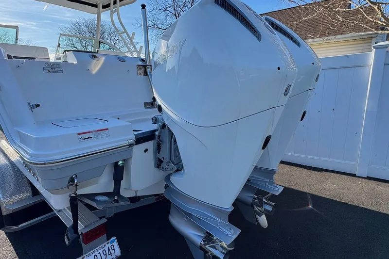 Slide: The Image of 2021 Blackfin 252 DC boat with dual Mercury outboard engines, parked on a trailer. - 38