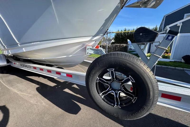 Slide: The Image of 2021 Blackfin 252 DC boat on Robalo trailer, close-up of wheel and hull. - 44