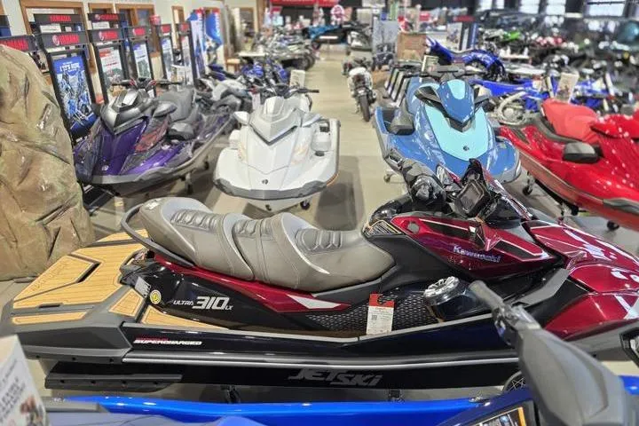 Slide: The Image of 2026 Kawasaki Jetski Ultra 310LX in showroom, surrounded by various watercraft models. - 6