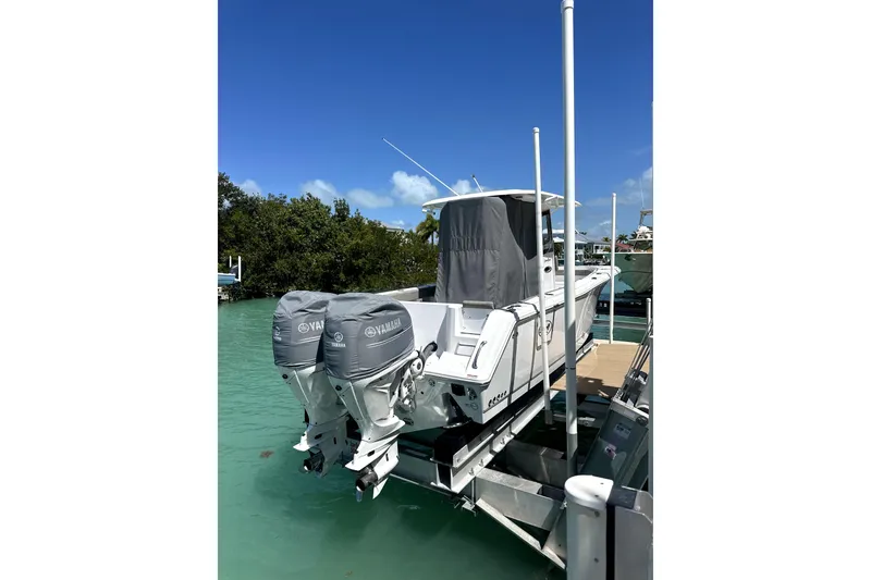 Slide: The Image of 2025 Sea Hunt Gamefish 28 with Yamaha engines docked on turquoise water. - 7