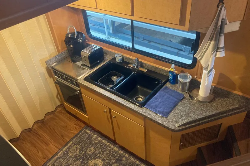 Slide: The Image of Compact kitchen in a 2006 Gibson 44 boat with sink, stove, and appliances. - 14