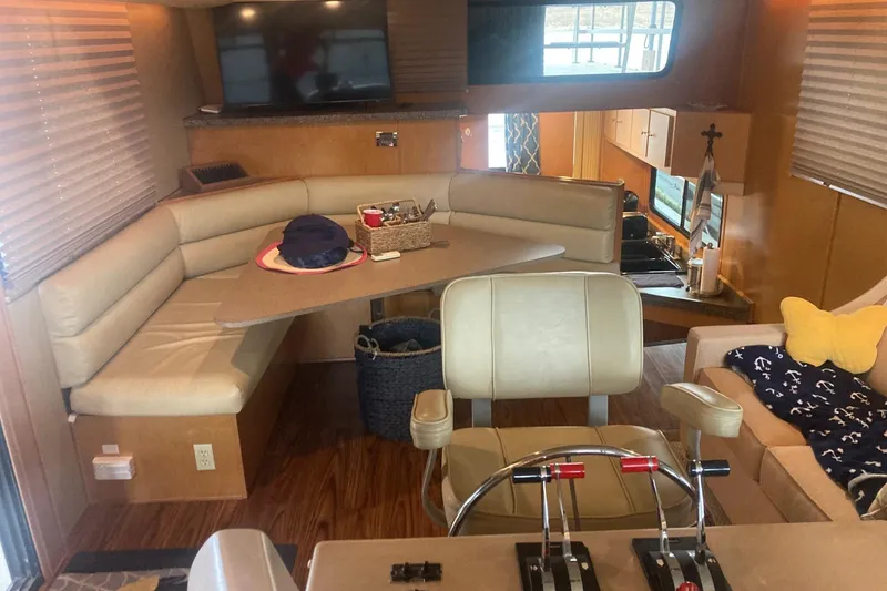 Slide: The Image of Interior of a 2006 Gibson 44 boat with seating, table, and helm controls. - 15