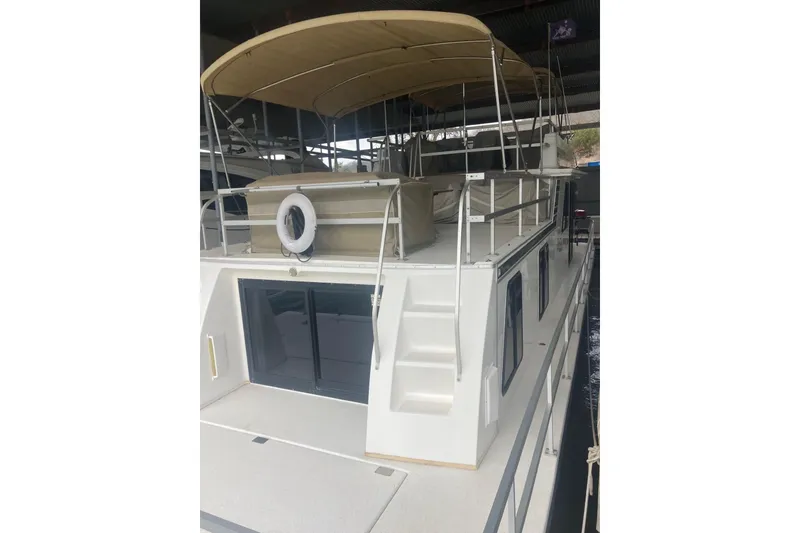 Slide: The Image of 2006 Gibson 44 houseboat with covered upper deck and sliding glass doors. - 2