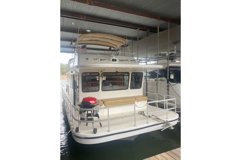 Slide: The Image of 2006 Gibson 44 boat docked under a covered marina. - 3