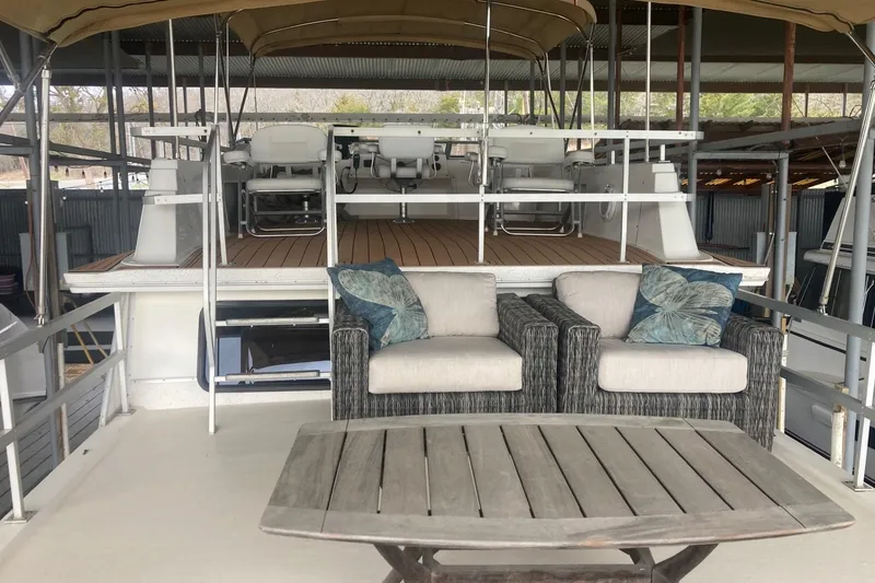 Slide: The Image of Outdoor seating area on a 2006 Gibson 44 boat with cushioned chairs and table. - 6
