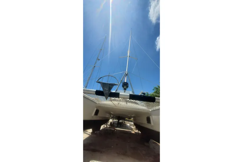 Slide: The Image of 1992 Fountaine Pajot Ninou catamaran with sails, viewed from below against a clear blue sky. - 12