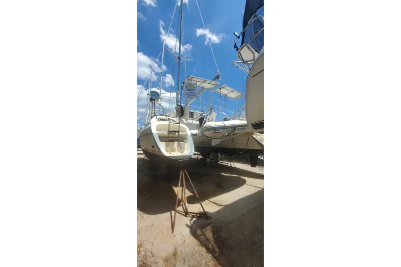 Slide: The Image of 1992 Fountaine Pajot Ninou catamaran on dry dock under a clear blue sky. - 13