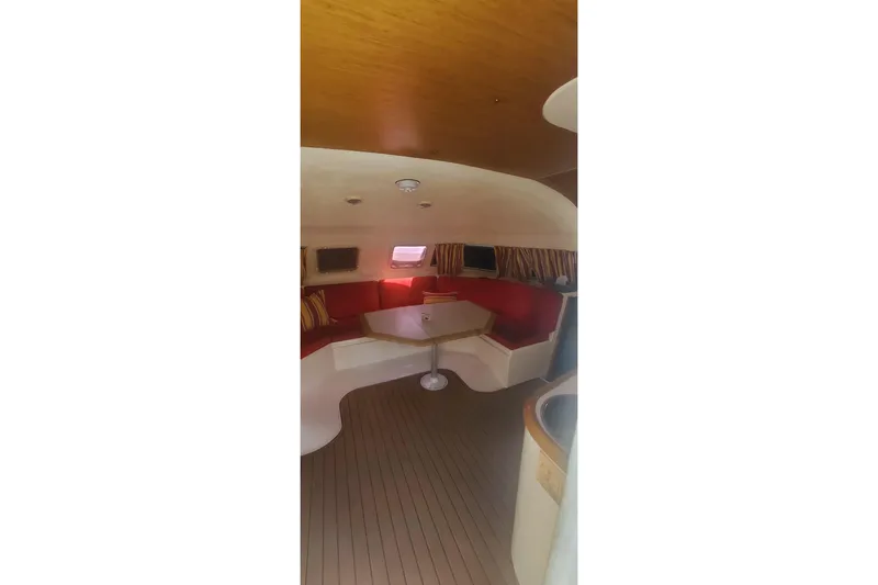Slide: The Image of Interior of 1992 Fountaine Pajot Ninou catamaran with red seating and wooden flooring. - 18