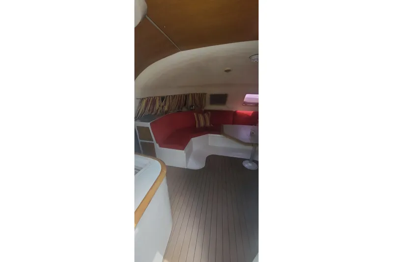 Slide: The Image of Interior of 1992 Fountaine Pajot Ninou with red seating and wooden flooring. - 19