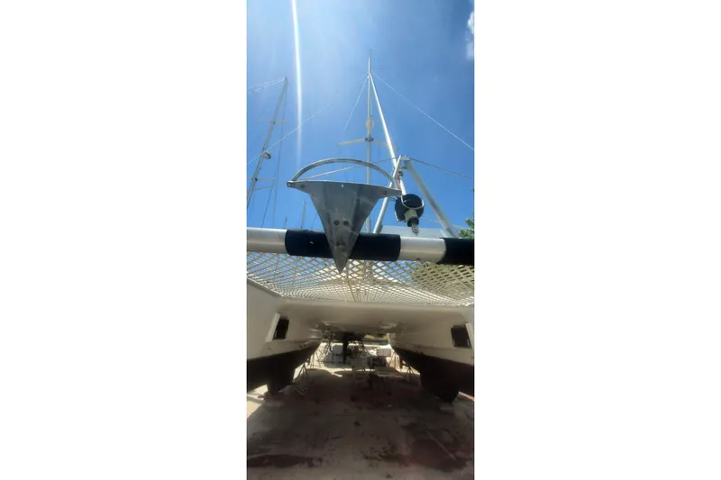 Slide: The Image of 1992 Fountaine Pajot Ninou catamaran, viewed from below, with clear blue sky. - 7