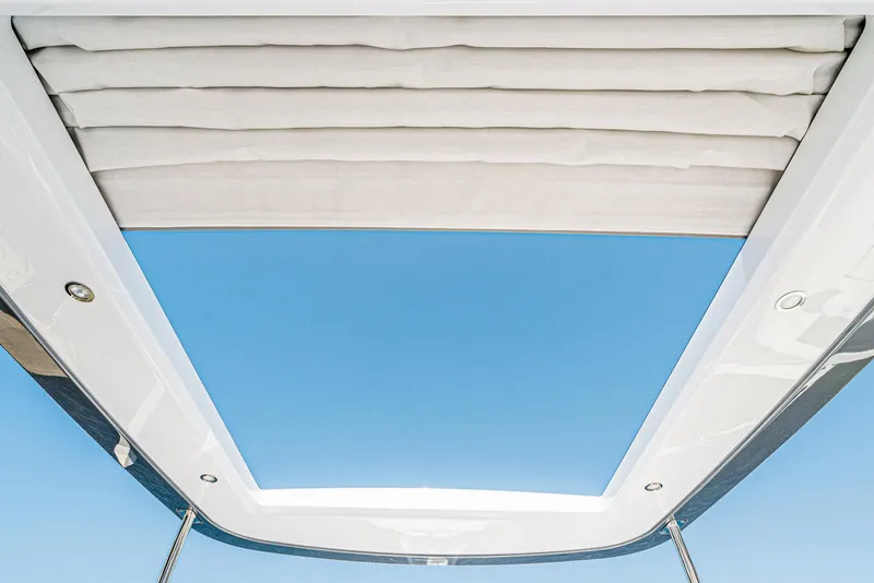 Slide: The Image of Azimut Fly 53 yacht sunroof, 2024 model, open to clear blue sky. - 19