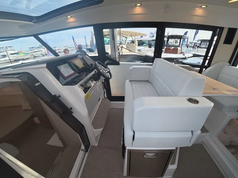 Slide: The Image of Interior view of a modern boat with white seating area, helm console, and large windows. - 9