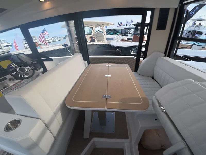 Slide: The Image of Interior of a 2027 Saxdor 340 GTWA with white cushioned seating and a wooden table. - 12