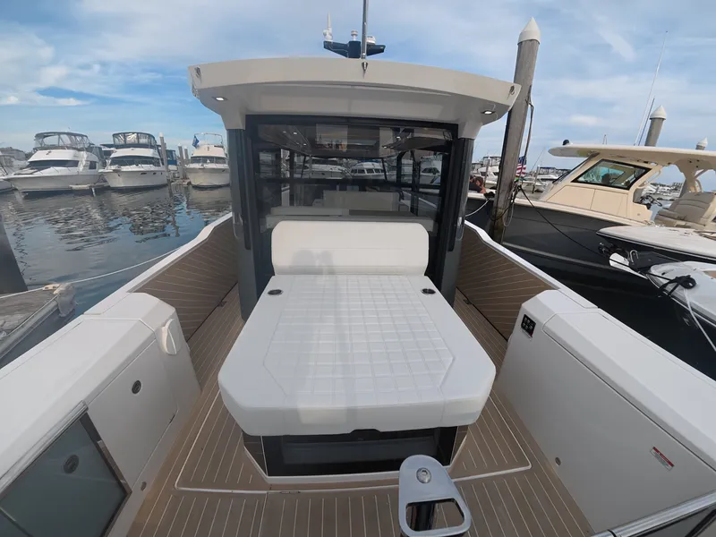 Slide: The Image of The image shows a modern boat with a spacious deck and lounging area, docked in a marina. - 7