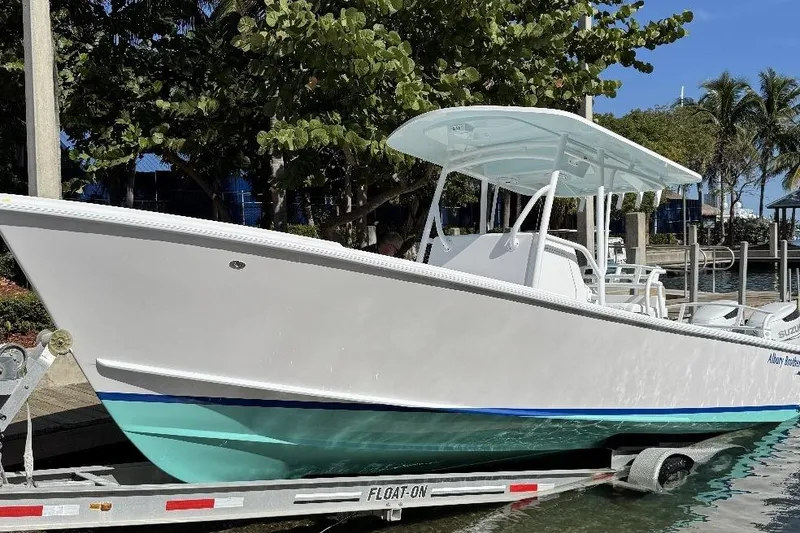 Slide: The Image of 2026 Albury Brothers 27 boat on trailer by waterfront, under sunny skies. - 1