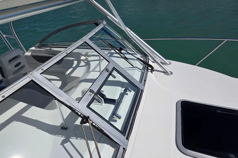 Slide: The Image of 2007 Boston Whaler 305 Conquest boat deck with open windshield and seating area. - 12