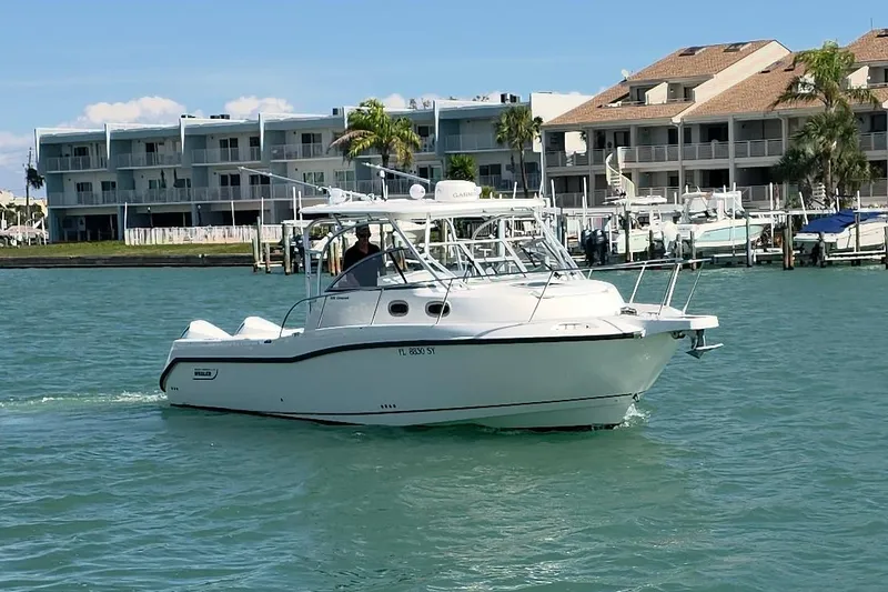 Slide: The Image of 2007 Boston Whaler 305 Conquest boat cruising near waterfront buildings. - 20