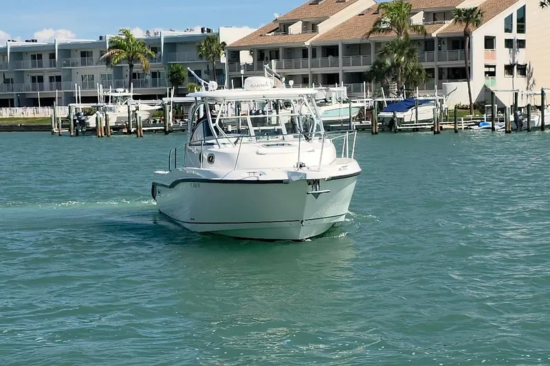 Slide: The Image of 2007 Boston Whaler 305 Conquest boat cruising near waterfront buildings. - 21