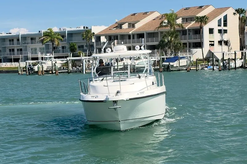 Slide: The Image of 2007 Boston Whaler 305 Conquest boat cruising near waterfront buildings. - 22
