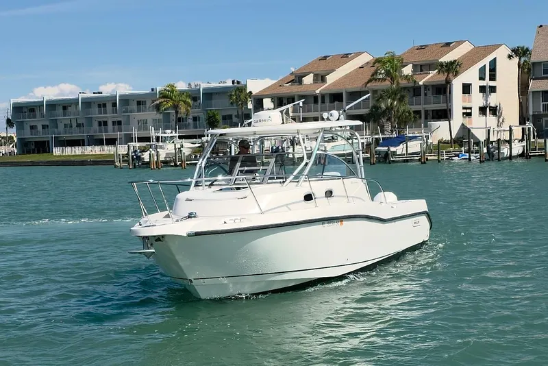 Slide: The Image of 2007 Boston Whaler 305 Conquest boat cruising near waterfront buildings. - 23