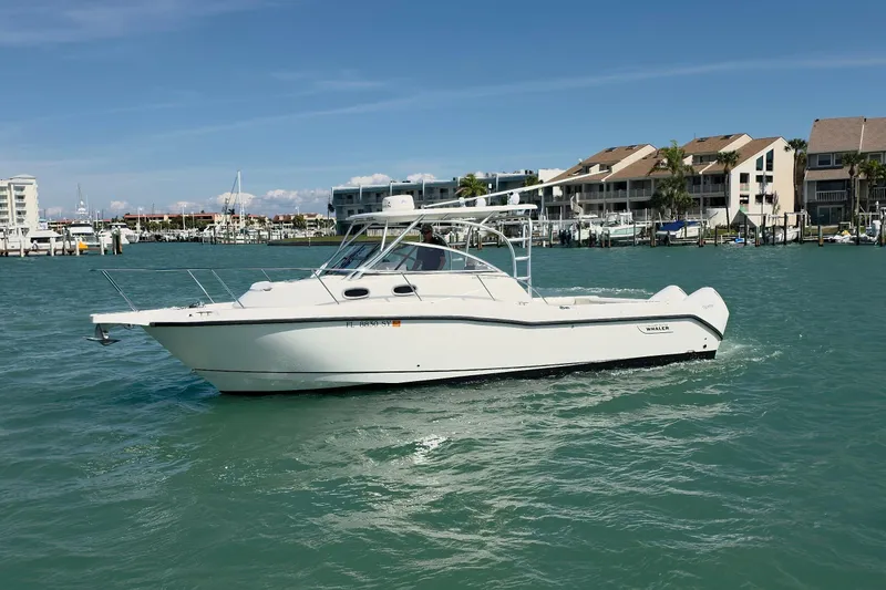 Slide: The Image of 2007 Boston Whaler 305 Conquest boat cruising near waterfront homes. - 25