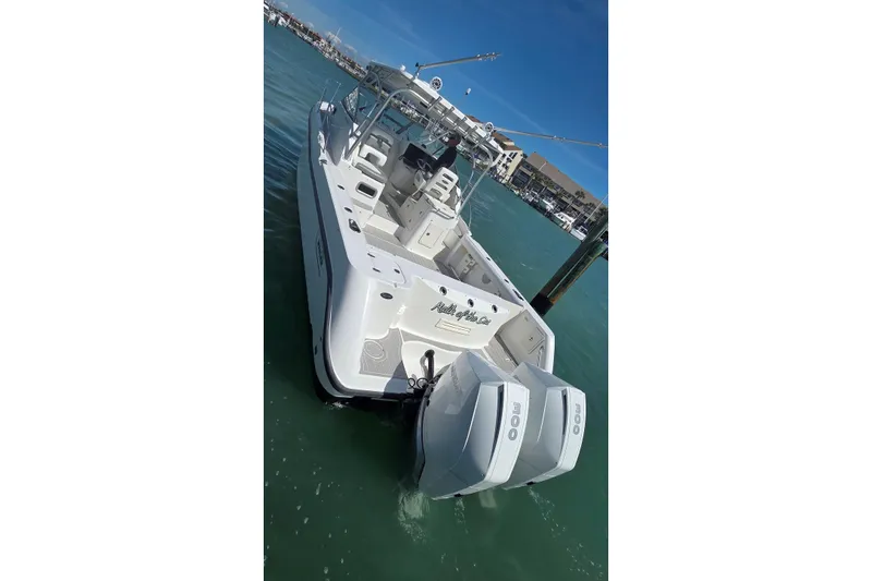Slide: The Image of 2007 Boston Whaler 305 Conquest boat docked in marina, featuring dual outboard engines. - 32