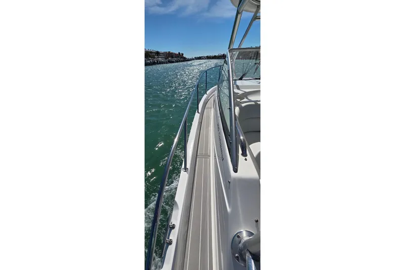 Slide: The Image of 2007 Boston Whaler 305 Conquest cruising on a sunny day, showcasing sleek design and clear waters. - 7