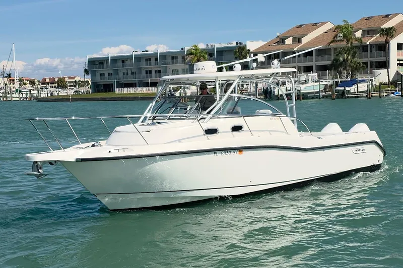 The Image of 2007 Boston Whaler 305 Conquest boat cruising on a sunny day near waterfront buildings. - 0
