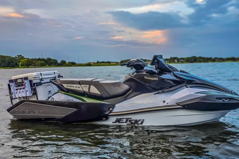 Slide: The Image of 2025 Kawasaki Ultra 160LX-S Angler jet ski on a serene lake at sunset. - 10
