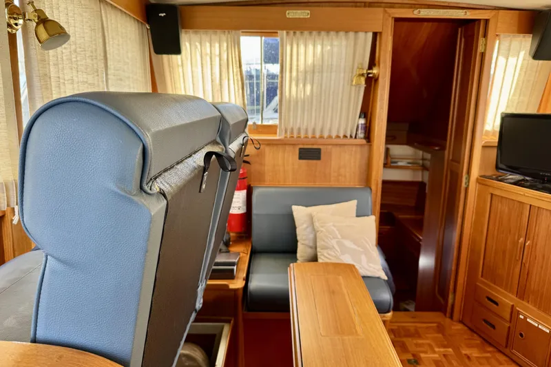 Slide: The Image of Interior of a 1997 Grandbanks 36 yacht with wooden furnishings and blue seating. - 12
