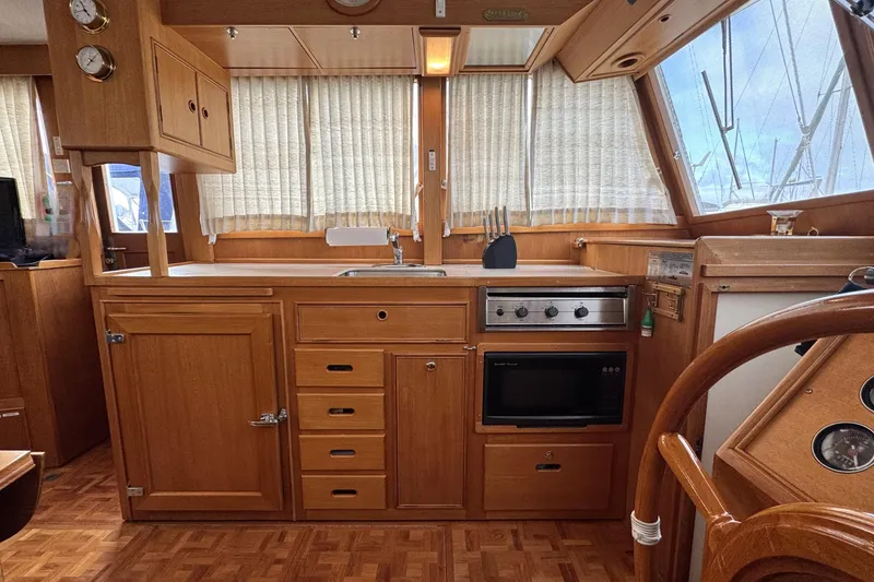 Slide: The Image of Interior of a 1997 Grandbanks 36 yacht kitchen with wooden cabinetry and appliances. - 13