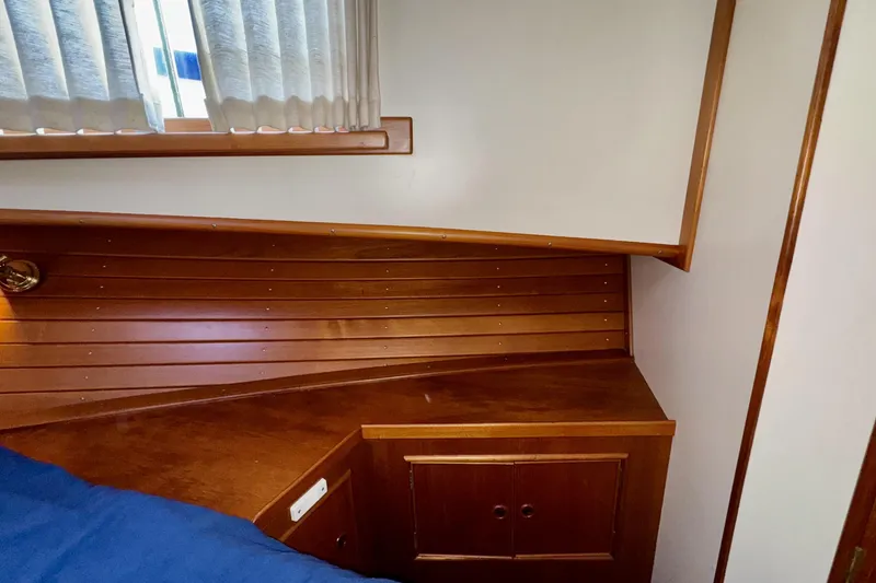 Slide: The Image of Interior cabin of 1997 Grandbanks 36 with wooden paneling and storage cabinet. - 18