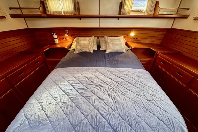 Slide: The Image of Cozy cabin interior of 1997 Grandbanks 36 with wooden furnishings and a neatly made bed. - 22