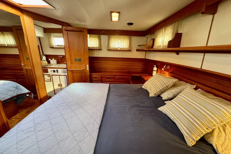 Slide: The Image of Luxurious 1997 Grandbanks 36 yacht cabin with cozy bed and elegant wood paneling. - 23