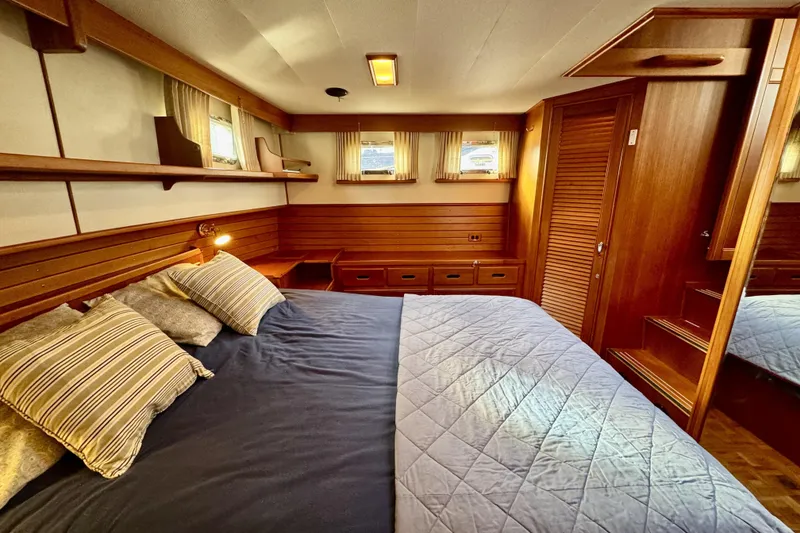 Slide: The Image of Cozy bedroom in 1997 Grandbanks 36 yacht with wood paneling and striped pillows. - 25