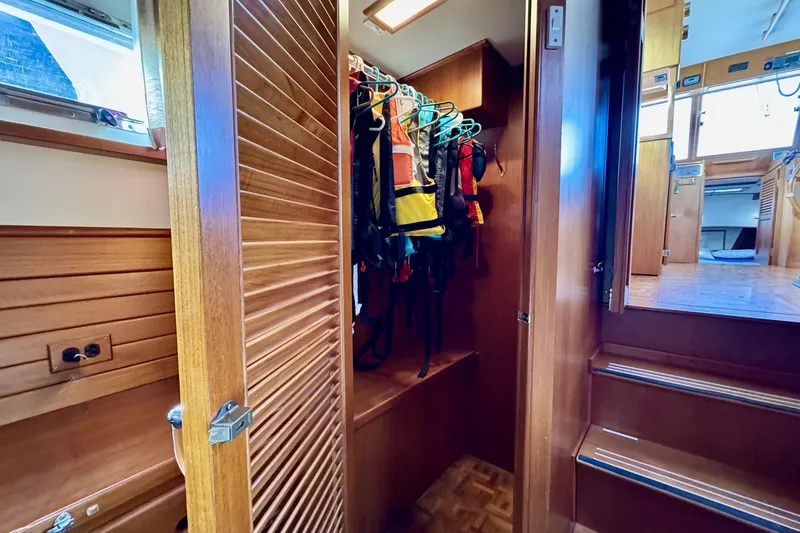 Slide: The Image of 1997 Grandbanks 36 interior closet with life jackets and wooden finishes. - 27