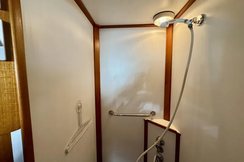 Slide: The Image of Shower area in a 1997 Grandbanks 36 boat, featuring wooden trim and modern fixtures. - 30