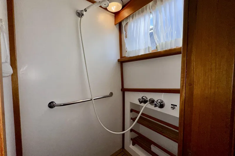 Slide: The Image of Shower area in 1997 Grandbanks 36 boat with wooden accents and curtain. - 35