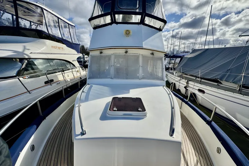 Slide: The Image of 1997 Grandbanks 36 yacht docked among other boats under a cloudy sky. - 36