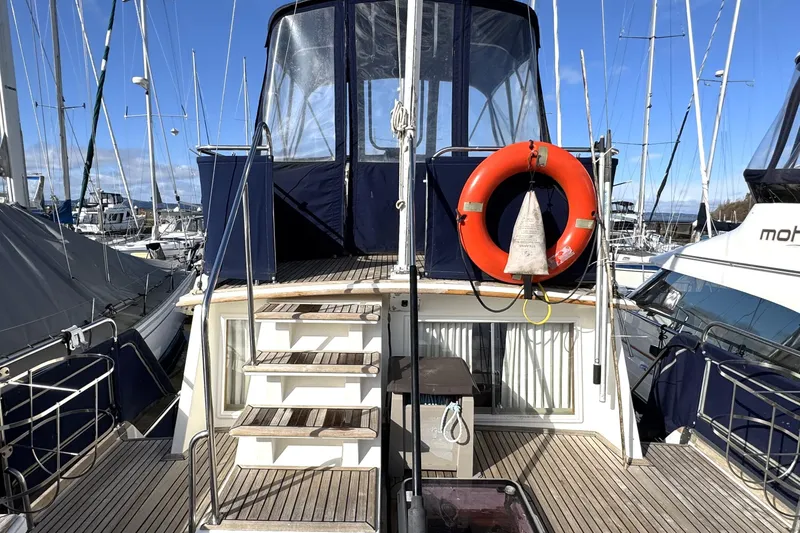 Slide: The Image of 1997 Grandbanks 36 yacht docked, featuring a life preserver and wooden deck. - 42