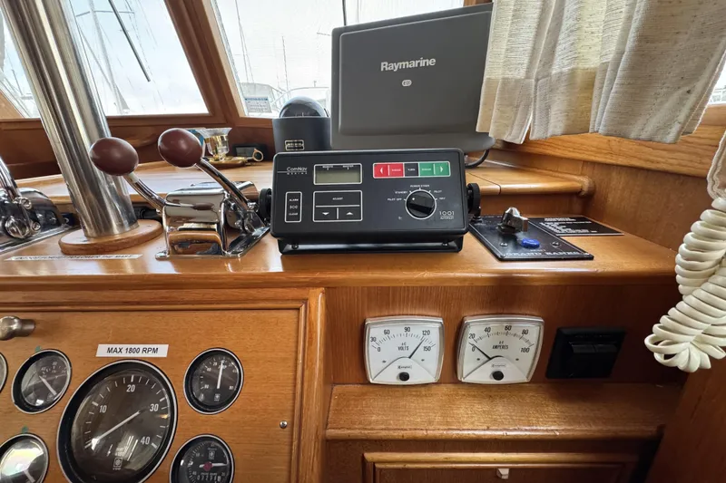 Slide: The Image of 1997 Grandbanks 36 helm with Raymarine equipment and control panel, featuring gauges and throttle levers. - 5