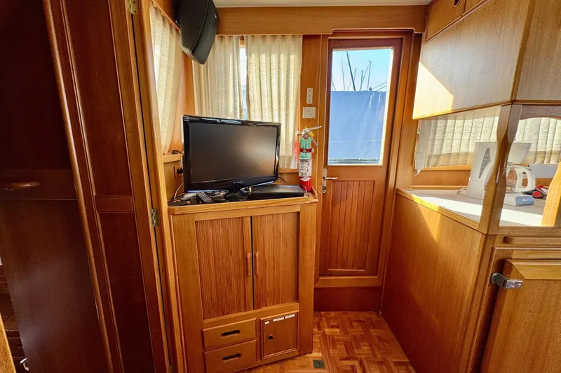 Slide: The Image of Interior of a 1997 Grandbanks 36 boat with wooden cabinetry and a mounted TV. - 6