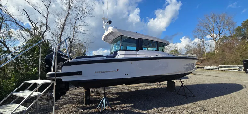 Slide: The Image of 2024 Axopar 29 boat on dry dock under sunny skies. - 2