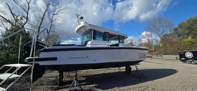 Slide: The Image of 2024 Axopar 29 boat on dry land under blue sky. - 3