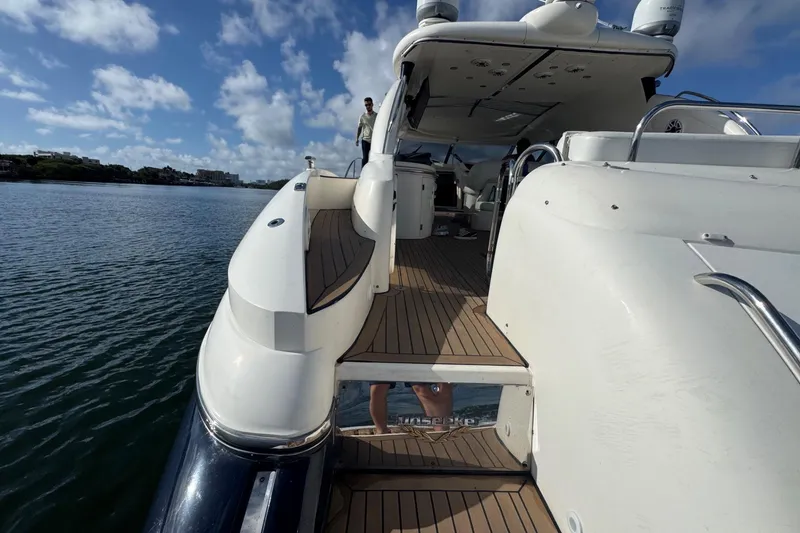 Slide: The Image of Sunseeker Predator 56 yacht, 2000 model, docked on calm water under a blue sky. - 10