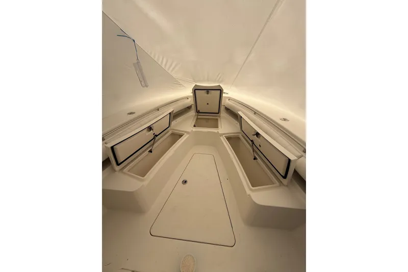 Slide: The Image of 2015 Regulator 28 Forward Seating boat interior with storage compartments open. - 20