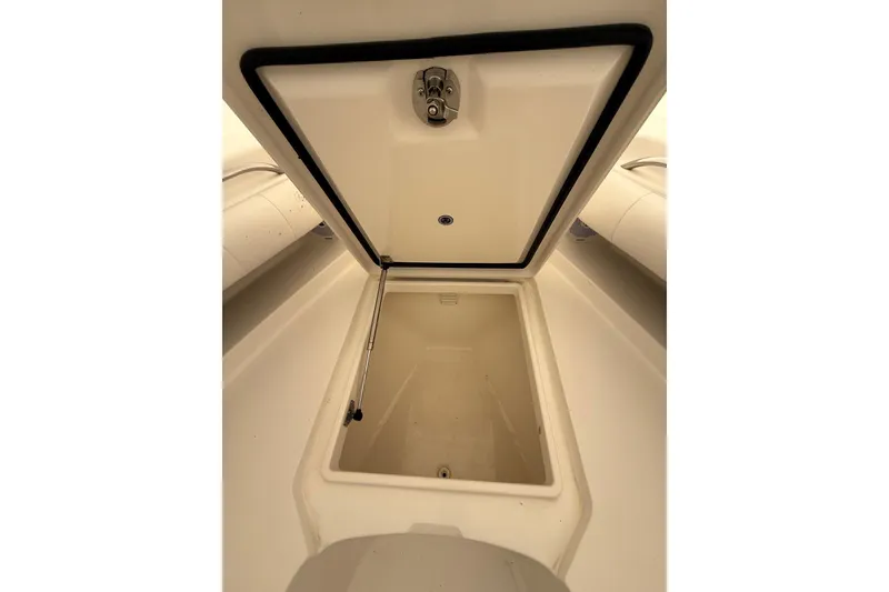 Slide: The Image of Open storage compartment on a 2015 Regulator 28 Forward Seating boat. - 23