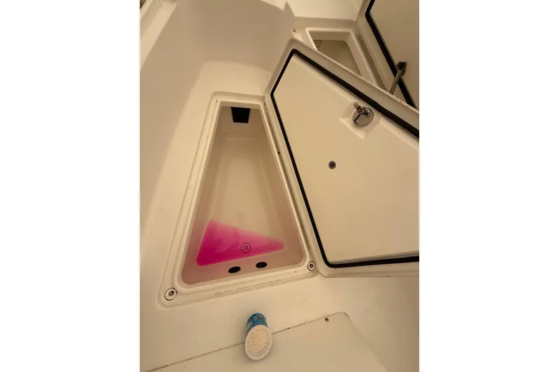 Slide: The Image of 2015 Regulator 28 Forward Seating storage compartment with pink liquid and open hatch. - 24