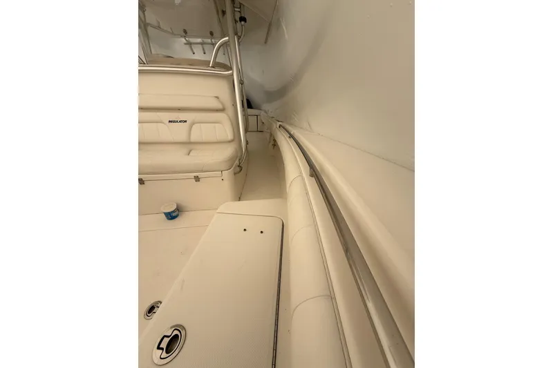Slide: The Image of 2015 Regulator 28 Forward Seating boat interior with cushioned seats and storage compartments. - 26